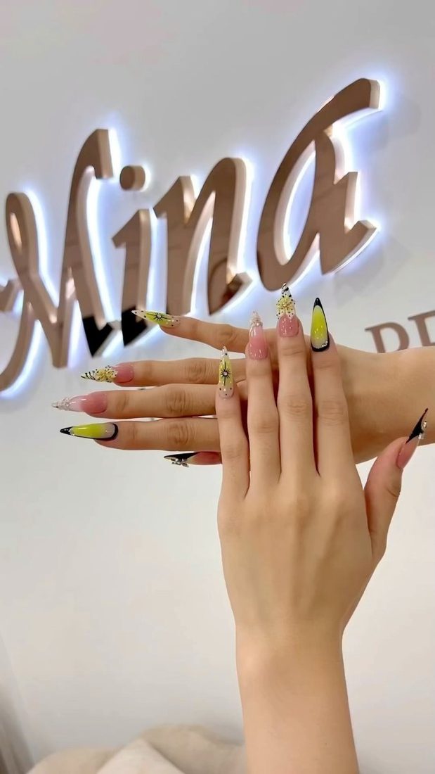 Kundin mit Nail Art vor der Leuchtschrift Mina